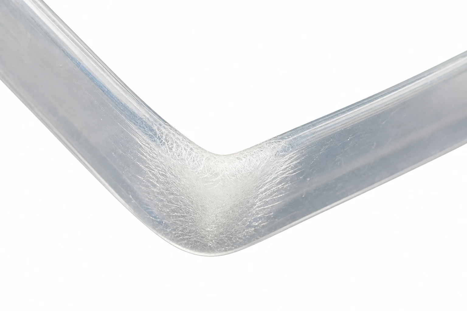 Close-up of a plastic sheet bent at a sharp angle showing a pale whitened crease